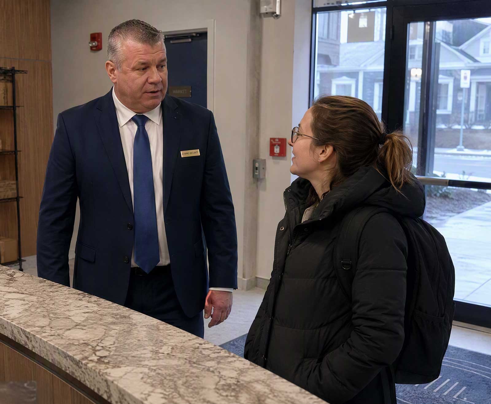 CITIPRO concierge security officer assisting a customer at the front desk