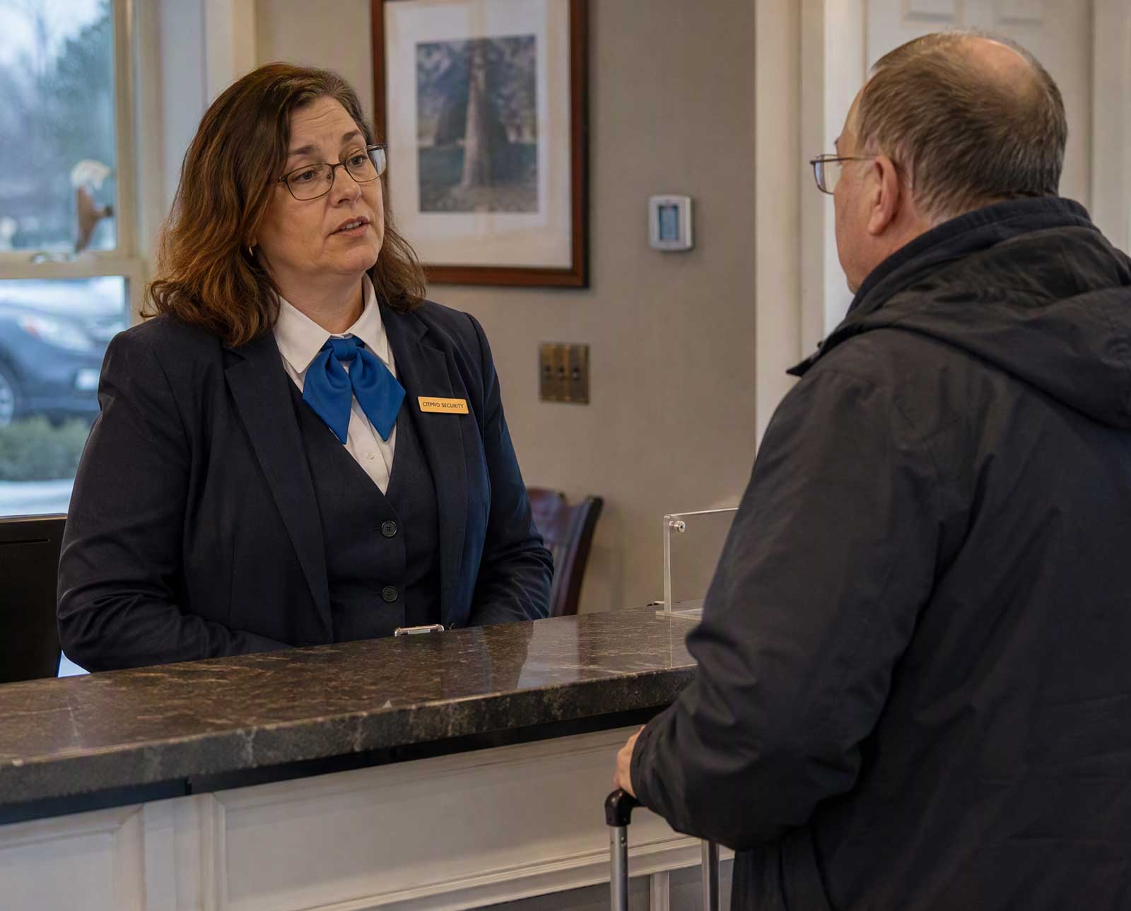 CITIPRO concierge security officer assisting a guest at a front desk